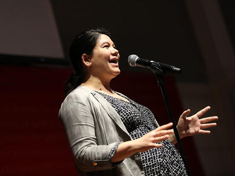 Woman speaking into a microphone at Double Take event