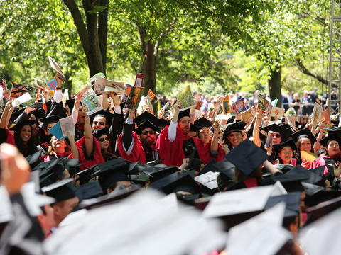 Commencement graduates holding books